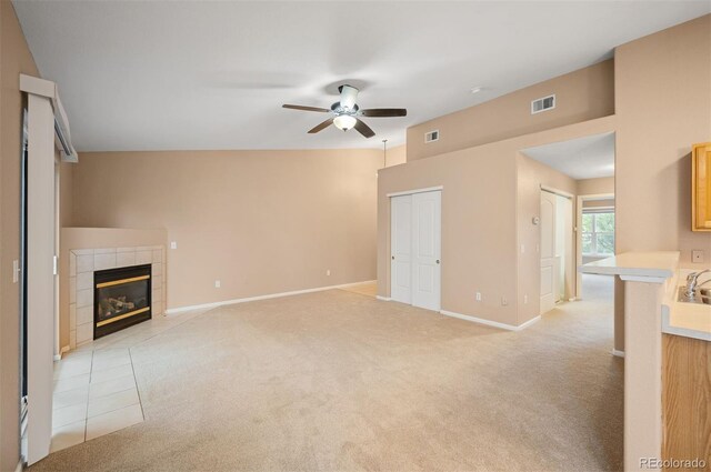 11640 W 62nd Pl Unit 203, Arvada, CO 80004 - unfurnished living room with a ceiling fan, light colored carpet, and a tile fireplace