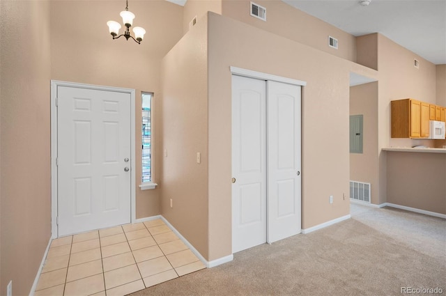 11640 W 62nd Pl Unit 203, Arvada, CO 80004 - foyer entrance featuring a towering ceiling, a chandelier, electric panel, and light colored carpet