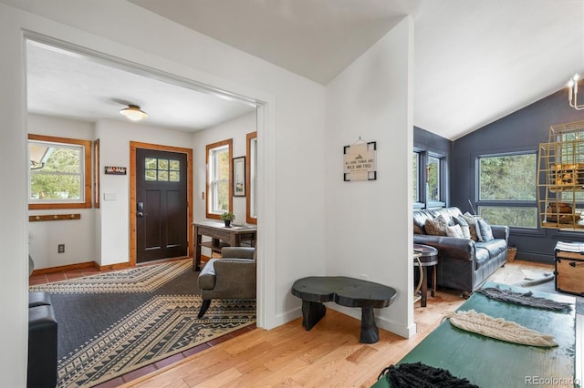 foyer entrance with lofted ceiling and light wood-type flooring