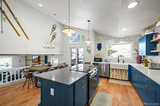 kitchen featuring a kitchen island, appliances with stainless steel finishes, blue cabinetry, and sink