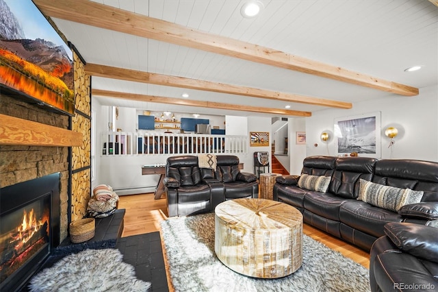 living room featuring beamed ceiling, hardwood / wood-style flooring, a baseboard heating unit, and a fireplace