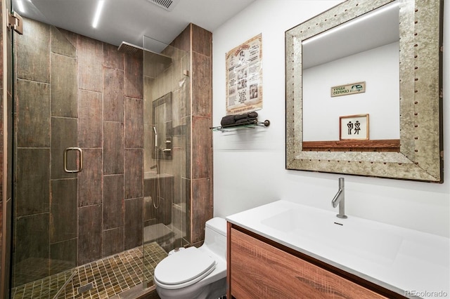 bathroom featuring vanity, an enclosed shower, and toilet