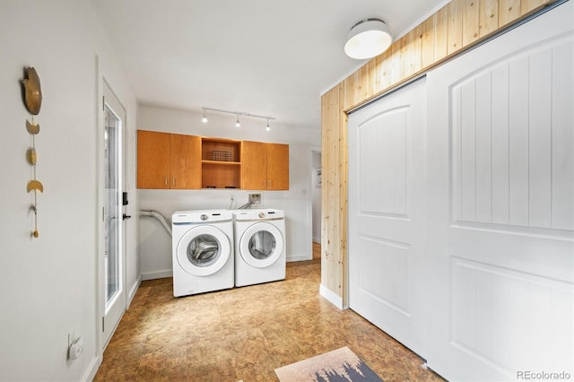 laundry room featuring washer and clothes dryer and cabinets