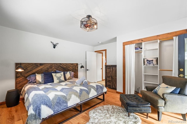 bedroom with light wood-type flooring and a closet