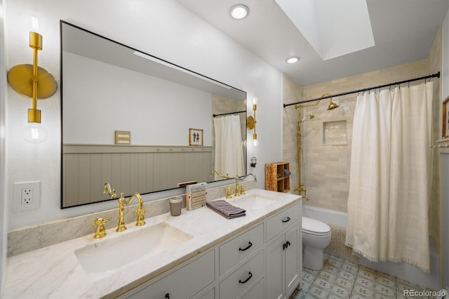 full bathroom with vanity, toilet, shower / tub combo with curtain, and a skylight