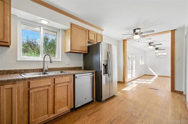 7065 Ingalls Ct, Arvada, CO 80003 - kitchen with stainless steel appliances, a sink, dark countertops, a ceiling fan, and light wood-style flooring