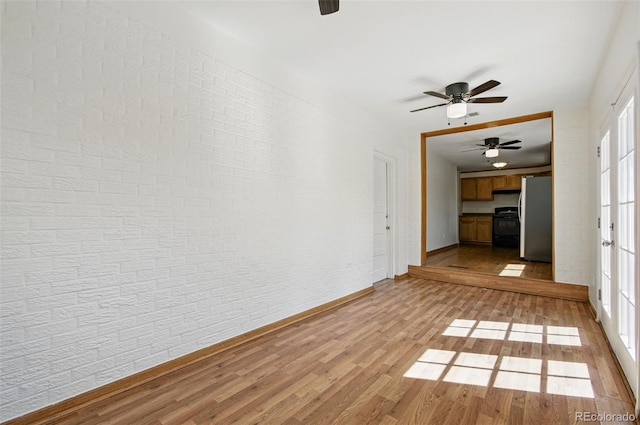 7065 Ingalls Ct, Arvada, CO 80003 - unfurnished room with a ceiling fan, light wood-type flooring, baseboards, and brick wall