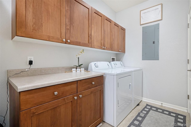 clothes washing area featuring electric panel, cabinets, and washing machine and clothes dryer