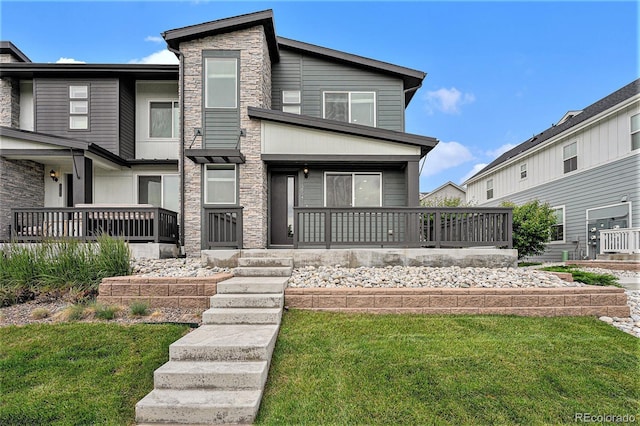 2054 S Upham Way, Denver, CO 80227 - view of front of property featuring stone siding, a porch, and a front lawn