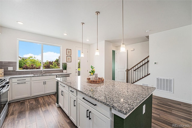 2054 S Upham Way, Denver, CO 80227 - kitchen featuring a kitchen island, light stone counters, dark wood-style floors, white cabinetry, and recessed lighting