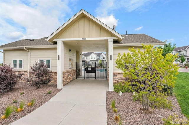 2054 S Upham Way, Denver, CO 80227 - doorway to property featuring stone siding, board and batten siding, and roof with shingles