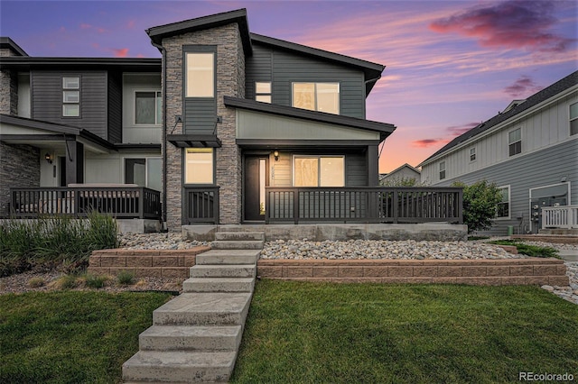 2054 S Upham Way, Denver, CO 80227 - contemporary house with stone siding, covered porch, and a lawn