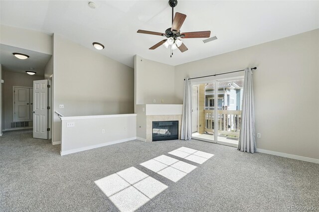 9434 Ashbury Cir Unit 203, Parker, CO 80134 - unfurnished living room featuring carpet flooring, baseboards, a tile fireplace, ceiling fan, and vaulted ceiling