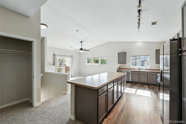 9434 Ashbury Cir Unit 203, Parker, CO 80134 - kitchen with lofted ceiling, a sink, light countertops, a kitchen island, and a ceiling fan