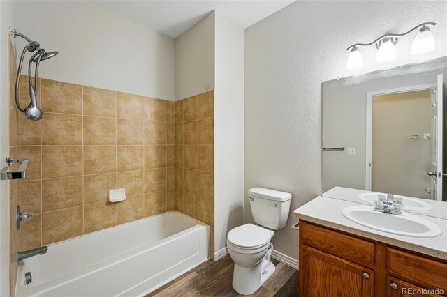 9434 Ashbury Cir Unit 203, Parker, CO 80134 - bathroom with wood finished floors, toilet, vanity, shower / washtub combination, and baseboards