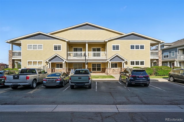 9434 Ashbury Cir Unit 203, Parker, CO 80134 - view of front facade with uncovered parking, a balcony, and stone siding