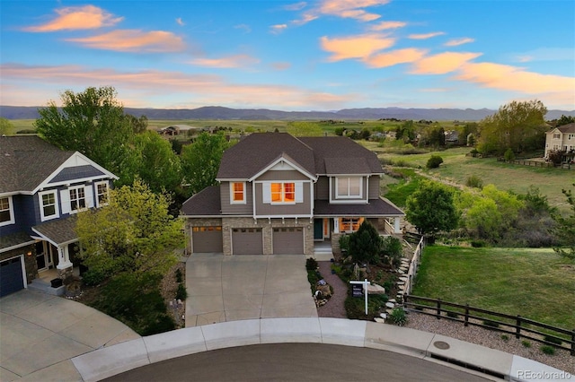 traditional-style home with concrete driveway, an attached garage, and a mountain view