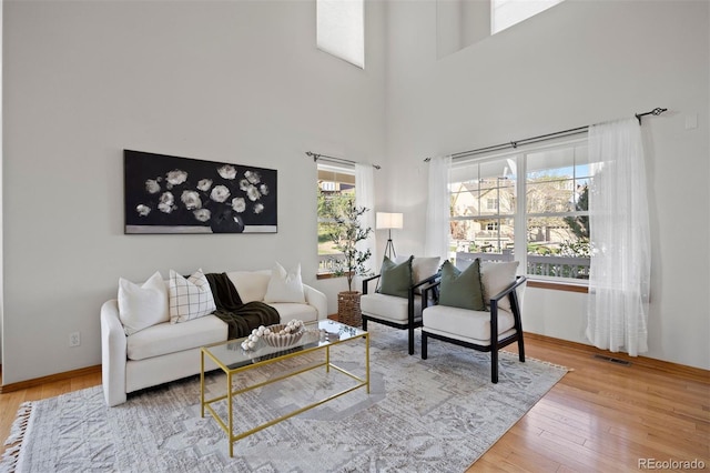 living room with wood finished floors, a high ceiling, and baseboards