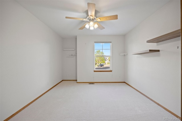 unfurnished room with ceiling fan, light colored carpet, and baseboards