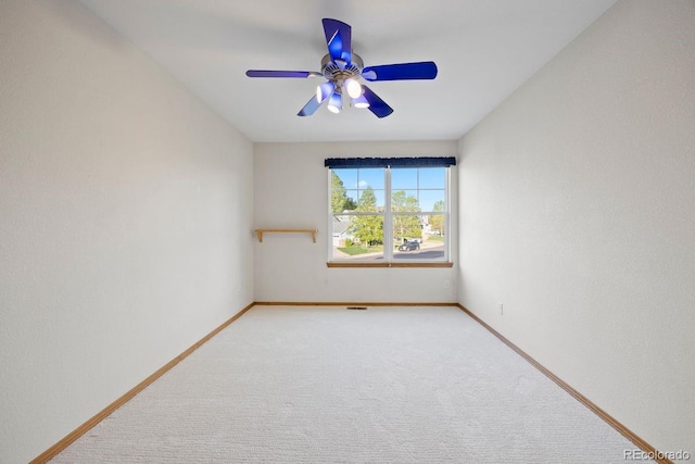 empty room with carpet flooring, a ceiling fan, and baseboards