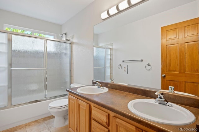full bath featuring tile patterned flooring, toilet, enclosed tub / shower combo, and double vanity