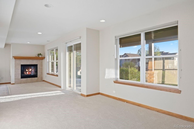 unfurnished living room with baseboards, carpet flooring, a fireplace, and recessed lighting