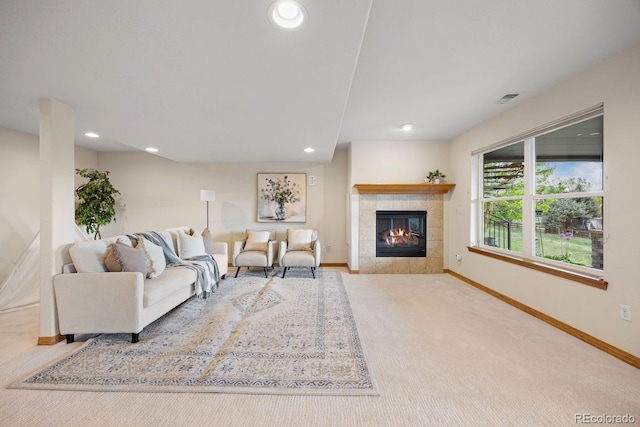 living room featuring baseboards, a tiled fireplace, recessed lighting, and carpet floors