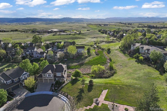 aerial view of property's location featuring a mountainous background and nearby suburban area