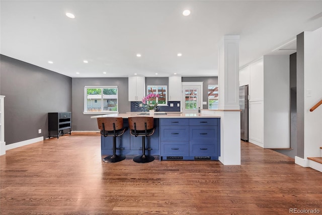 1346 S Grant St, Longmont, CO 80501 - kitchen featuring white cabinets, a center island, light countertops, wood finished floors, and recessed lighting
