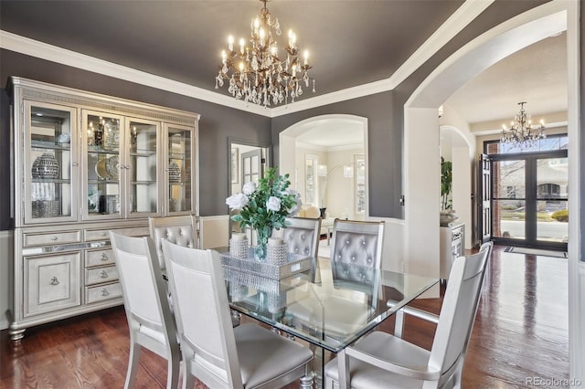 dining area featuring an inviting chandelier, french doors, dark hardwood / wood-style floors, and ornamental molding