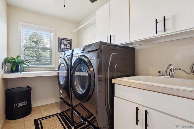 washroom with sink, cabinets, independent washer and dryer, and light tile patterned floors