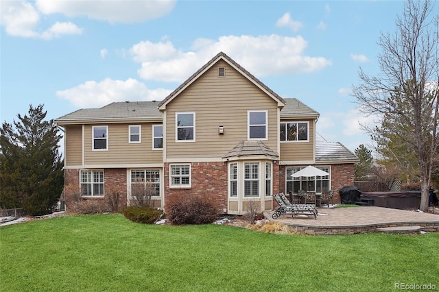 rear view of house featuring a patio area, a hot tub, and a lawn