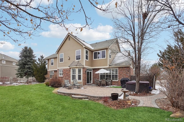 back of house with a hot tub, a patio, and a yard