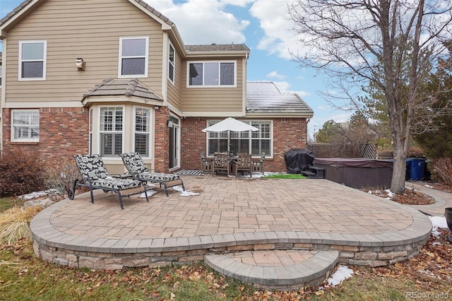 back of property with a patio area and a hot tub