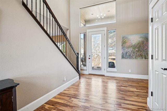 entryway with hardwood / wood-style flooring and a towering ceiling