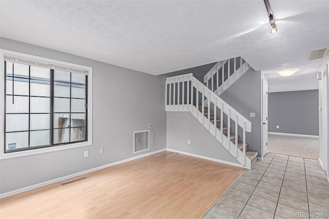 9328 Fenton Ct, Westminster, CO 80031 - unfurnished living room with a textured ceiling, stairs, and wood finished floors