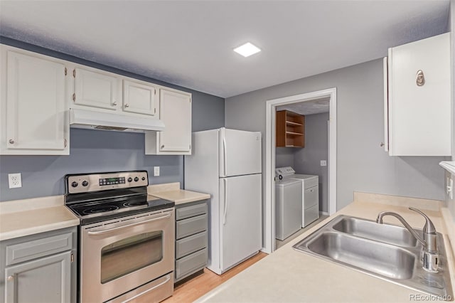 9328 Fenton Ct, Westminster, CO 80031 - kitchen featuring stainless steel range with electric stovetop, freestanding refrigerator, under cabinet range hood, washer and dryer, and light countertops
