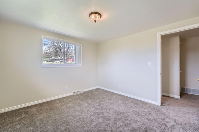 spare room featuring visible vents, carpet flooring, and baseboards