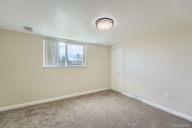 empty room with baseboards, carpet flooring, and visible vents