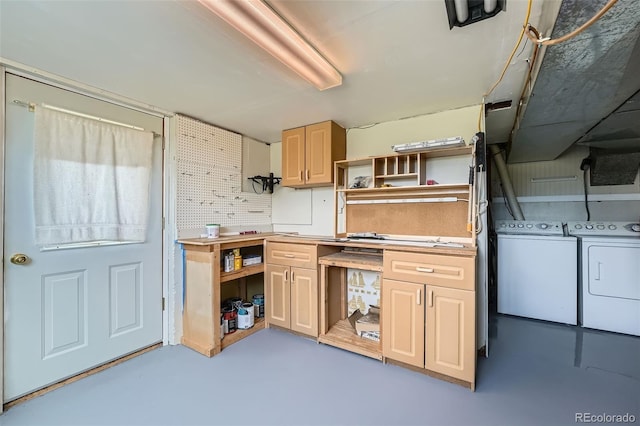 kitchen with open shelves, finished concrete flooring, and washing machine and dryer