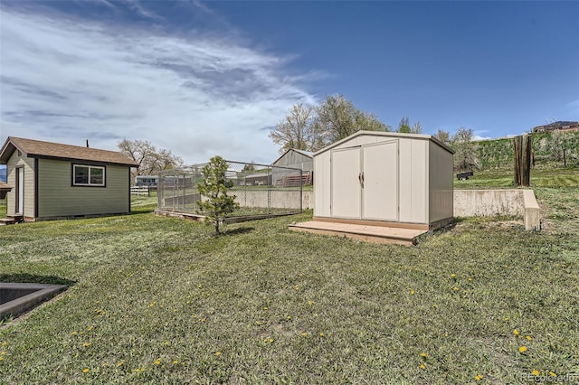 view of yard featuring fence, an outdoor structure, and a shed