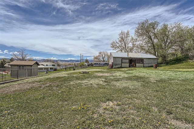 view of yard featuring fence and an outbuilding