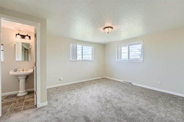13805 W 82nd Ave, Arvada, CO 80005 - unfurnished bedroom featuring carpet floors, a textured ceiling, baseboards, ensuite bathroom, and visible vents