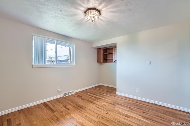 13805 W 82nd Ave, Arvada, CO 80005 - unfurnished room with baseboards, light wood finished floors, and visible vents
