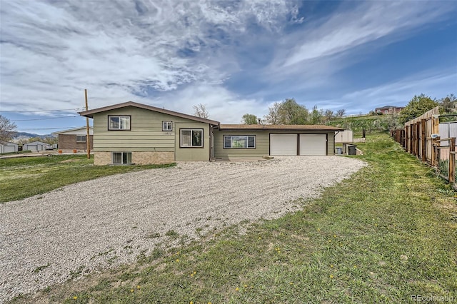13805 W 82nd Ave, Arvada, CO 80005 - split level home featuring fence, a garage, driveway, and a front lawn