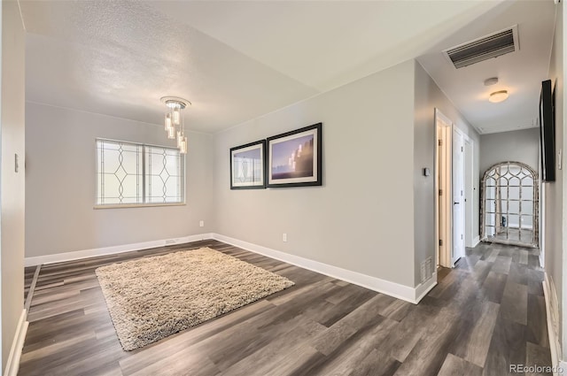 1477 S Wright St, Lakewood, CO 80228 - empty room with dark wood-style floors, healthy amount of natural light, baseboards, and a chandelier