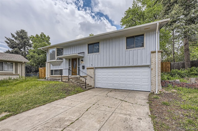 1477 S Wright St, Lakewood, CO 80228 - raised ranch with board and batten siding, concrete driveway, an attached garage, and brick siding