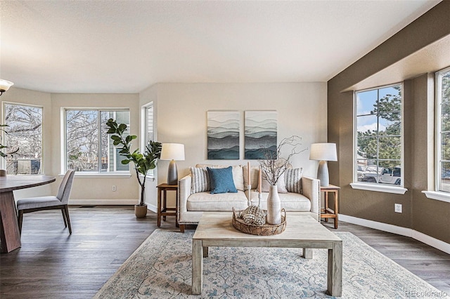 living room with baseboards, wood finished floors, visible vents, and a healthy amount of sunlight