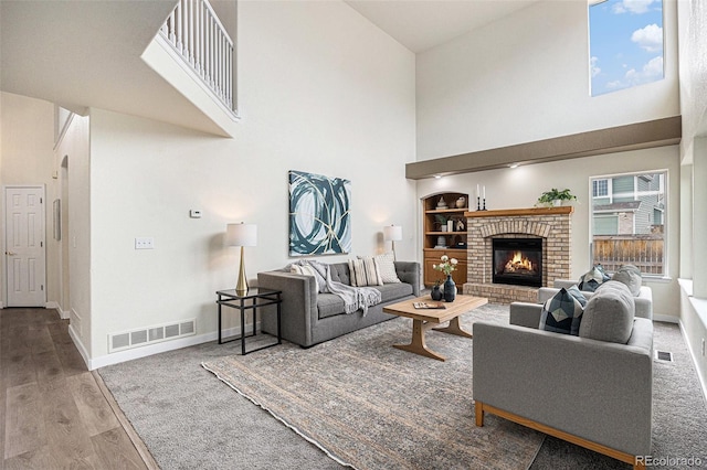 living room featuring visible vents, baseboards, and wood finished floors