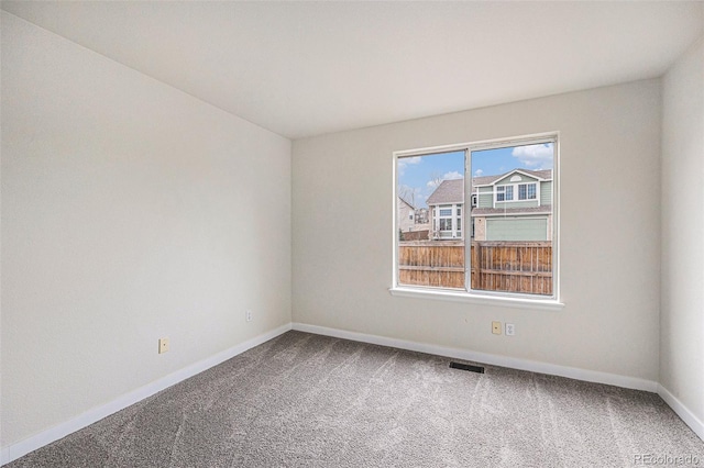 unfurnished room featuring baseboards, visible vents, and carpet flooring